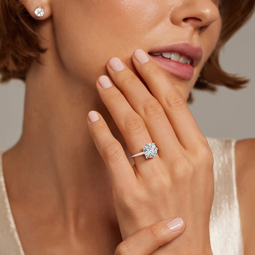 Solitaire diamond engagement ring in white gold worn on the hand